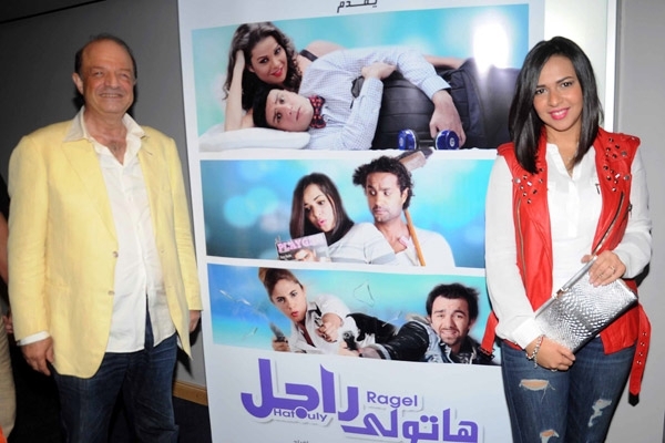 إيمي والمنتج محمد حسن رمزي مع أفيش الفيلم