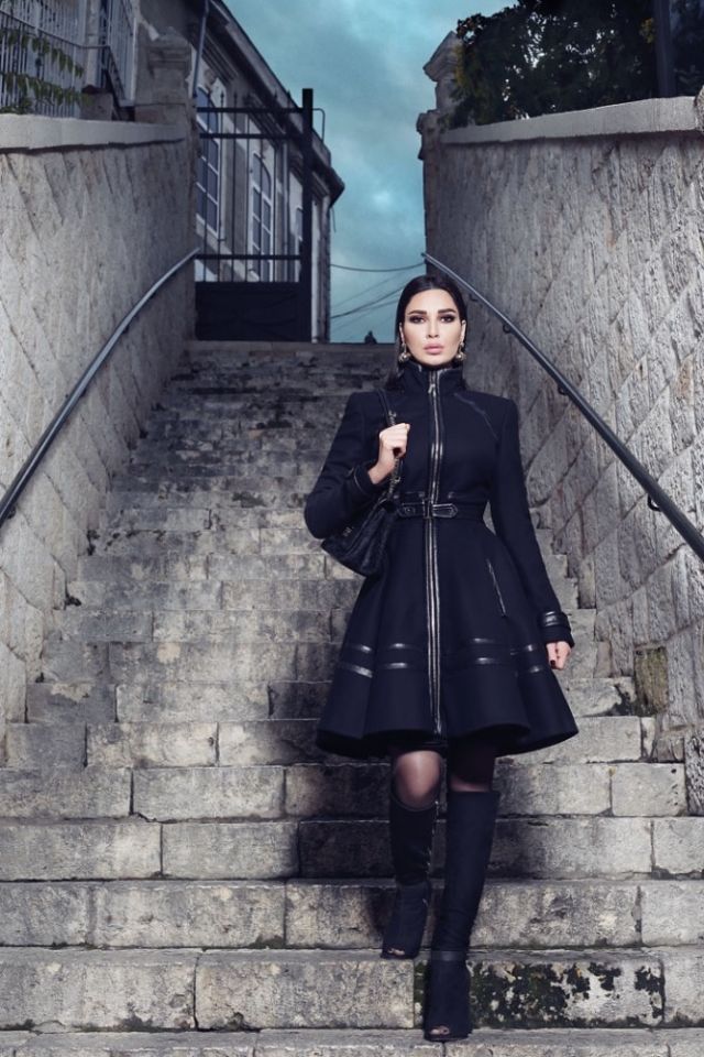 فستان على شكل معطف مع حزام، وجزمة، وحقيبة وأقراط للأذنين. الكل من Elie Saab.