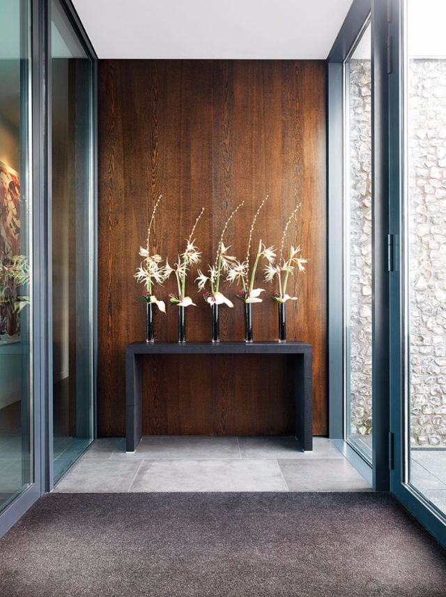 المدخل يلبس حلّة أنيقة، يزيّنه كونسول من الخشب، مُنسَّق بأوانٍ من الأزهار