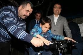 بالصور - أردوغان يهدي دراجة لطفل سوري ضربه بائع تركي