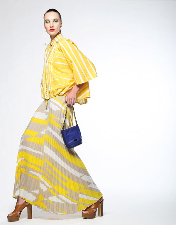 توب من القطن المخطط بالأصفر والأبيض وتنورة من الحرير المثنى من Max Mara. حذاء من Michael by Michael Kors. حقيبة من Mulberry.
