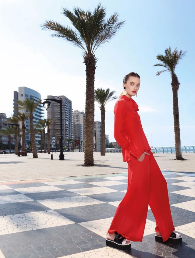 قميص وسروال من الحرير الأحمر من Rosetta Getty. أقراط للأذنين من Marni.
