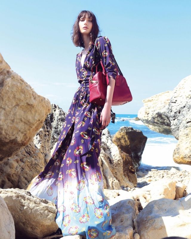 فستان طويل من الحرير المطبع وحقيبة من الجلد الأحمر من Marc Jacobs.
