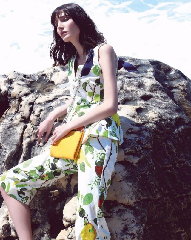 توب وسروال قصير مطبّعان من Sportmax. حقيبة صفراء من PG.
