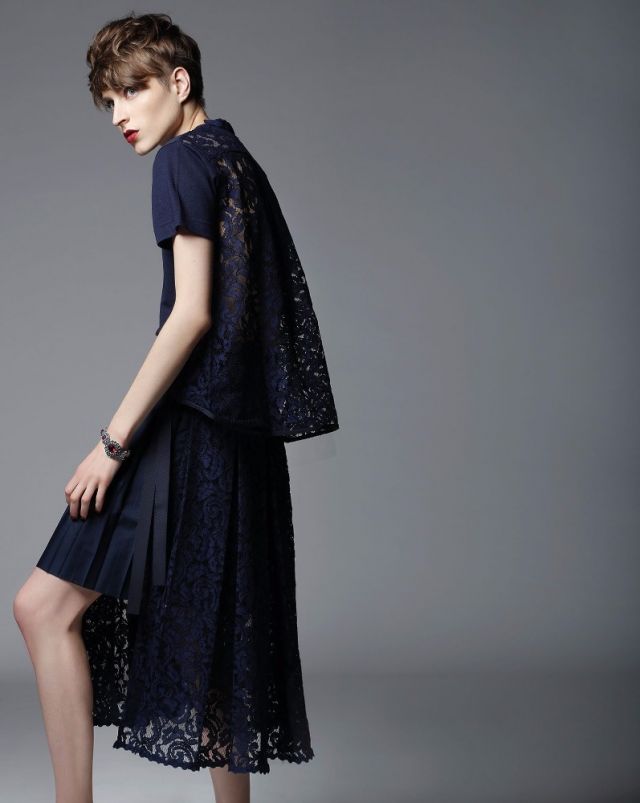 توب وتنورة من القطن الكحلي مع ظهر من الدانتيل من SACAI. سوار من Miu Miu.
