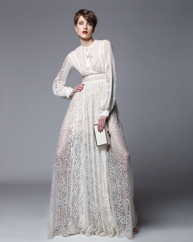 بلوزة من الحرير والدانتيل باللون الأبيض البيج مع فستان من الحرير والدانتيل. حقيبة صغيرة. الكل من Elie Saab.
