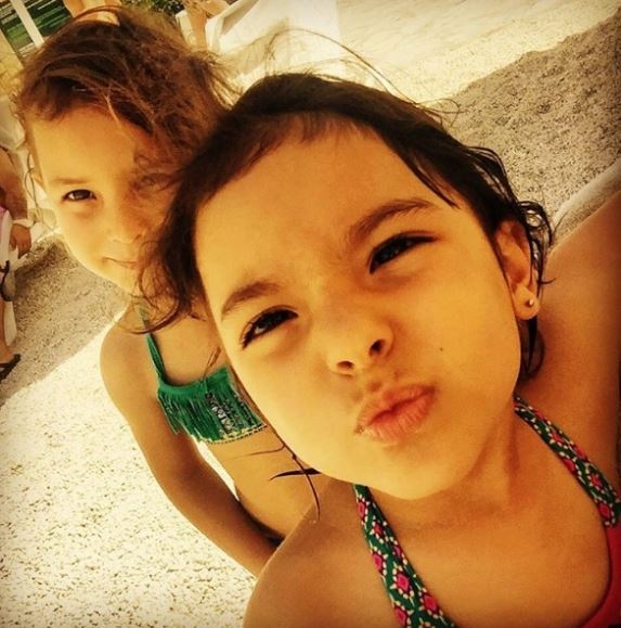 بالصور - خمنوا هاتين الطفلتين التوأم بنات أي نجمين شهيرين معهما على البحر؟!