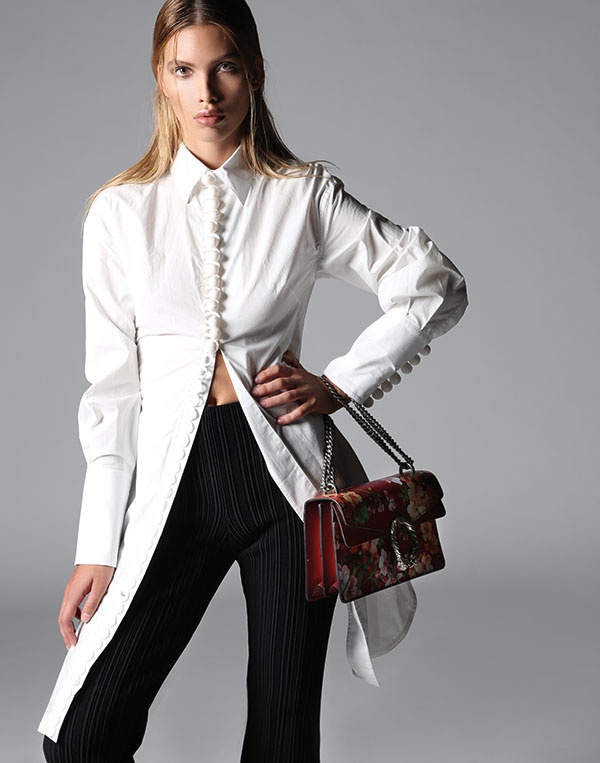 سروال من النسيج الأسود المحبوك، وبلوزة من القطن من Proenza Schouler. حقيبة من Gucci.
