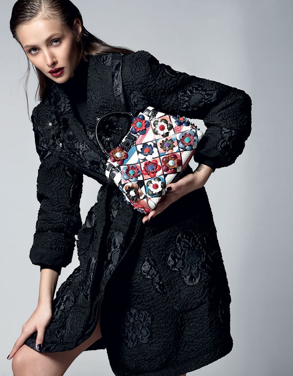 كنزة سوداء ومعطف أسود، وحقيبة من جلد الثعبان مزينة  بأزهار جلدية متعددة الألوان من Fendi.
