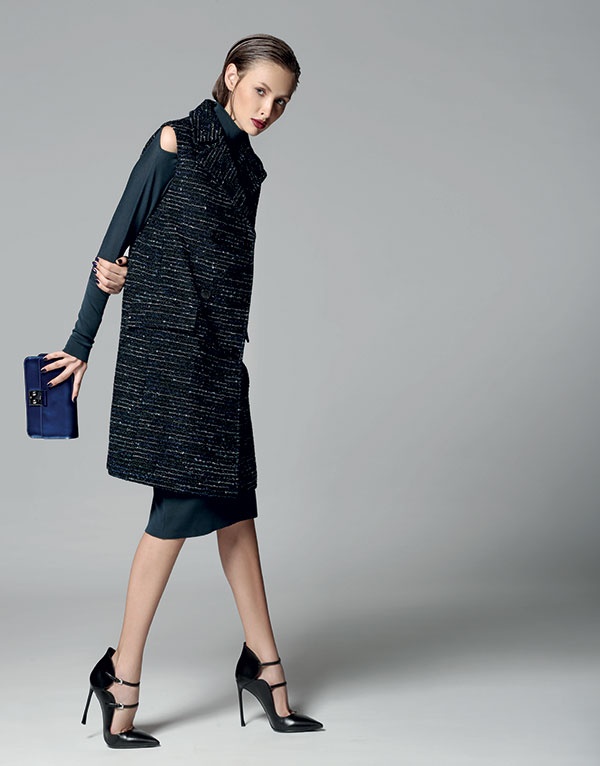 فستان من النسيج المحبوك وجيليه طويل من التويد، وحقيبة وحذاء. الكل من Dior.
