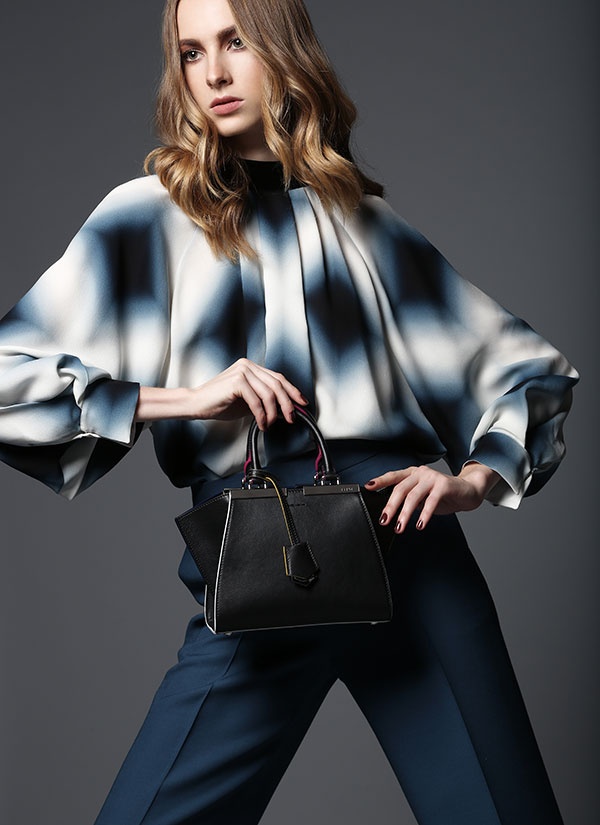 بلوزة من الحرير المطبع وسروال أزرق وحقيبة من الجلد من Fendi.
