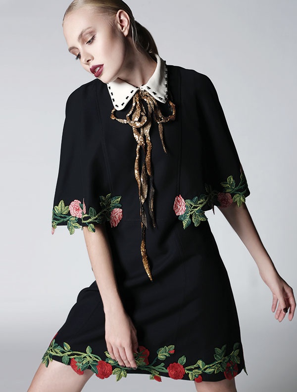 فستان أسود مطرز بالأزهار مع ياقة مزينة بالبرق اللماع من Gucci.
