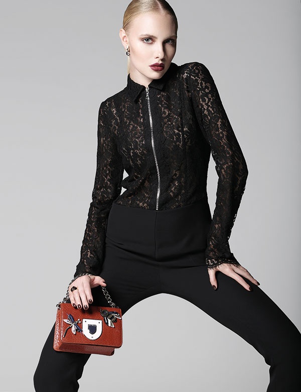 بذلة ذات قطعة واحدة من الكريب والدانتيل الأسود. أقراط للأذنين وخاتم وحقيبة. الكل من Dior.
