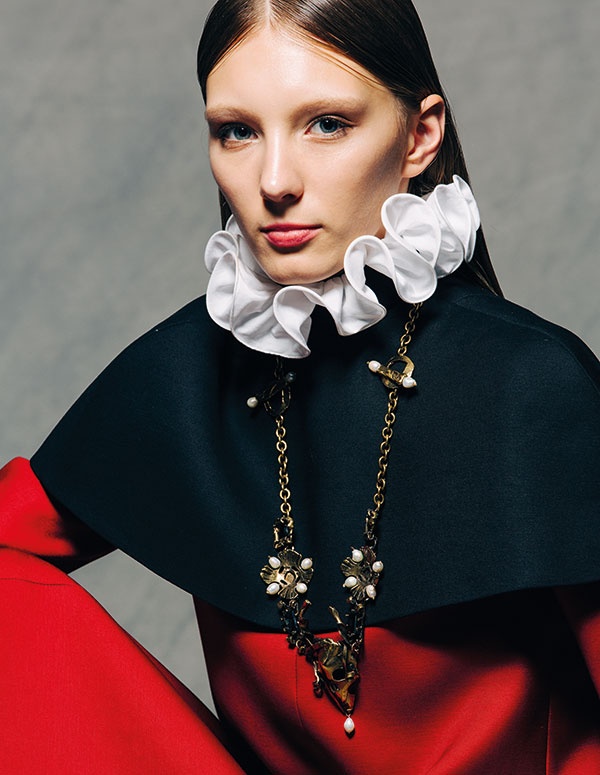 فستان من الصوف الأحمر تزيّنه ياقة مكشكشة بيضاء 
وكاب أسود قصير من
 VALENTINO Haute Couture

