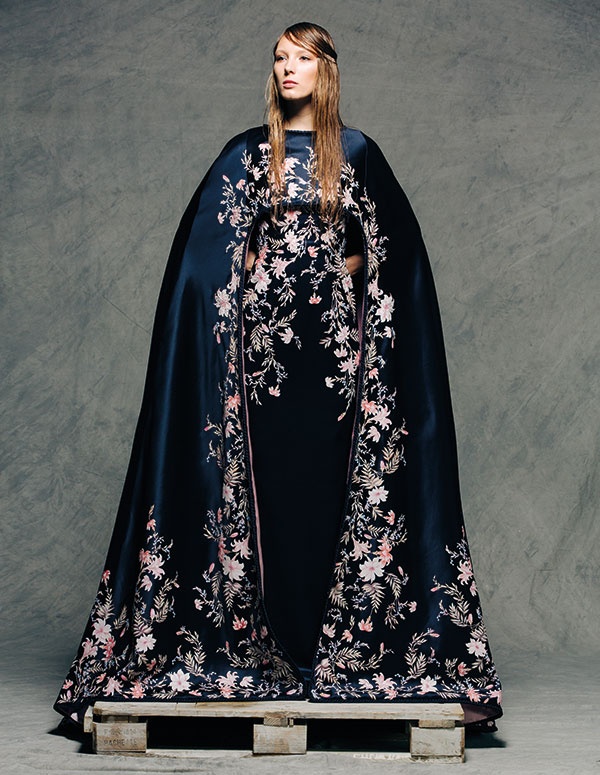 فستان من ساتين الحرير الكحلي مع رداء طويل حتى الأرض وحاشية مضفورة، إضافة إلى رسوم نباتية يدوية وزخارف من الكريستال والخرز الزجاجي والخيوط االمعدنية. منRALPH & RUSSO Couture.
