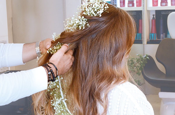 3● قسّمي شعرك إلى قسمين. لفّي الأزهار مع الشعر عند الجهة اليمنى، ثمّ طبّقي الأمر نفسه في الجهة اليسرى. 
