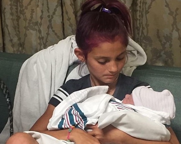 بالصور - طفلة تشارك طبيباً في ولادة شقيقها.. شاهدوا رد فعلها!