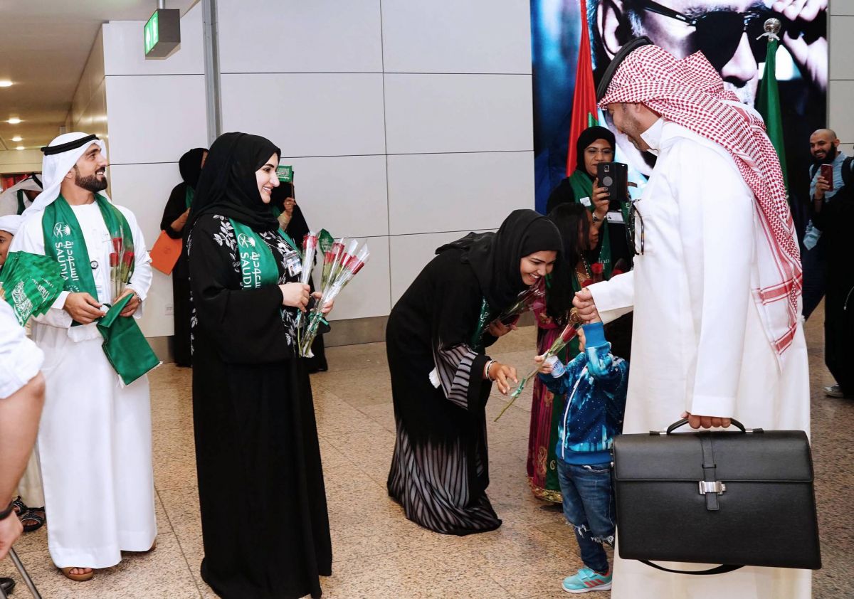 الورود والحلوي في استقبال السعوديين بمطارات دبي... شاهدوا الصور